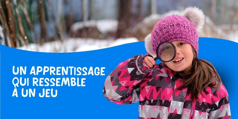 jeune fille portant un bonnet rose avec des pompons gris regardant à travers une loupe