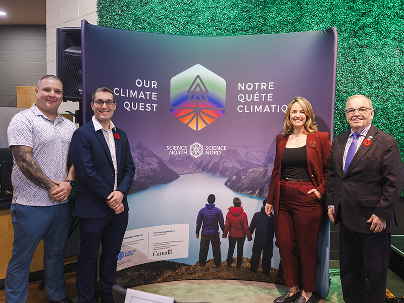 le pdg de science nord et d'autres personnes entourant la bannière notre quête climatique pour célébrer le lancement de l'exposition à terre dynamique